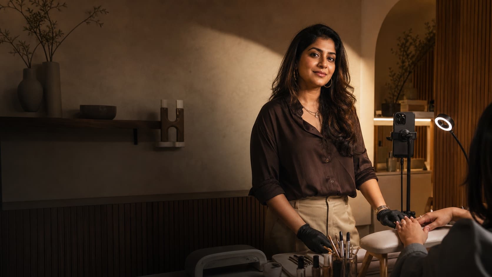 A nail artist standing confidently in her studio after a live session
